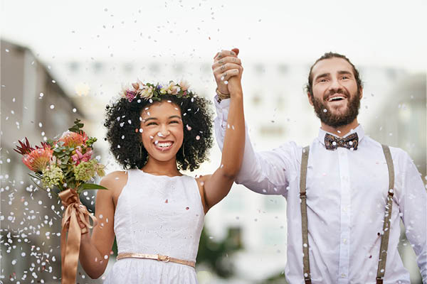 Married couple holding hands in the air and smiling