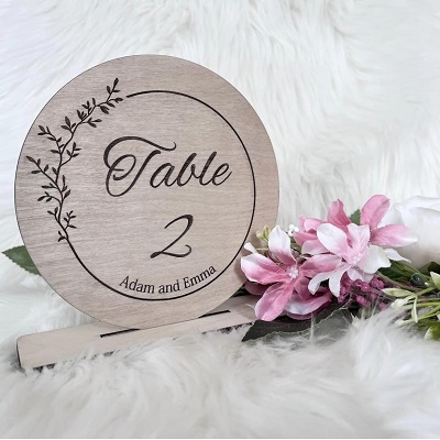 A decorative wooden circle with &quot;table 2&quot; carved on it.