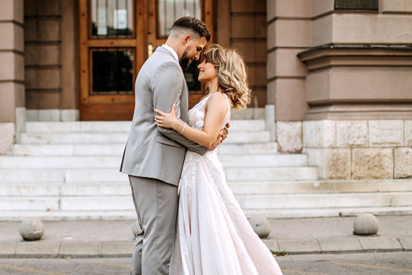 Wedding couple in front of building stairs looking into each others eyes