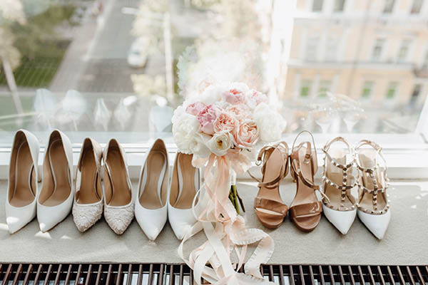 Wedding shoes lined up in a row on a window sill