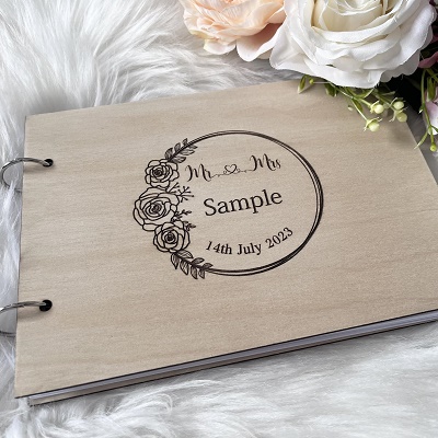 A wooden guestbook decorated with a flowery carving and names.